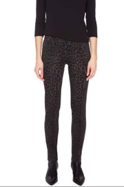 Woman wearing a black long-sleeve top and patterned leggings on a white background