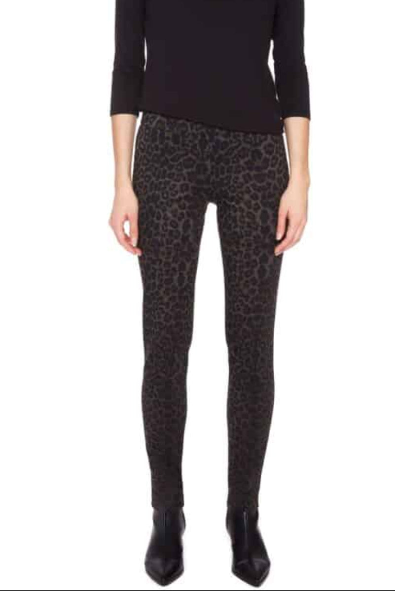 Woman wearing a black long-sleeve top and patterned leggings on a white background