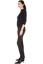 Woman wearing a black outfit with patterned leggings on a white background
