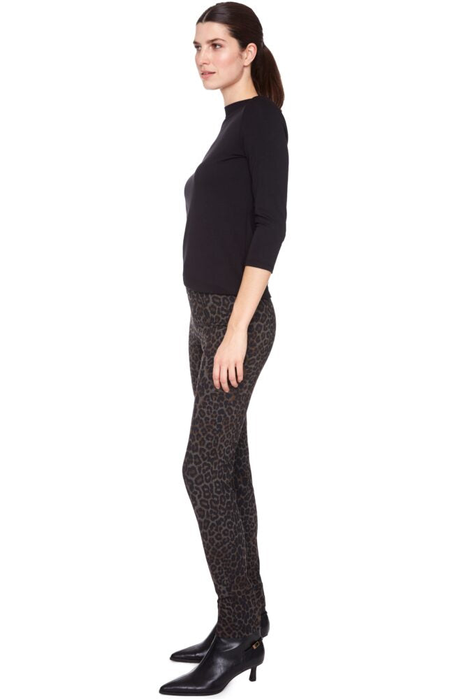 Woman wearing a black outfit with patterned leggings on a white background