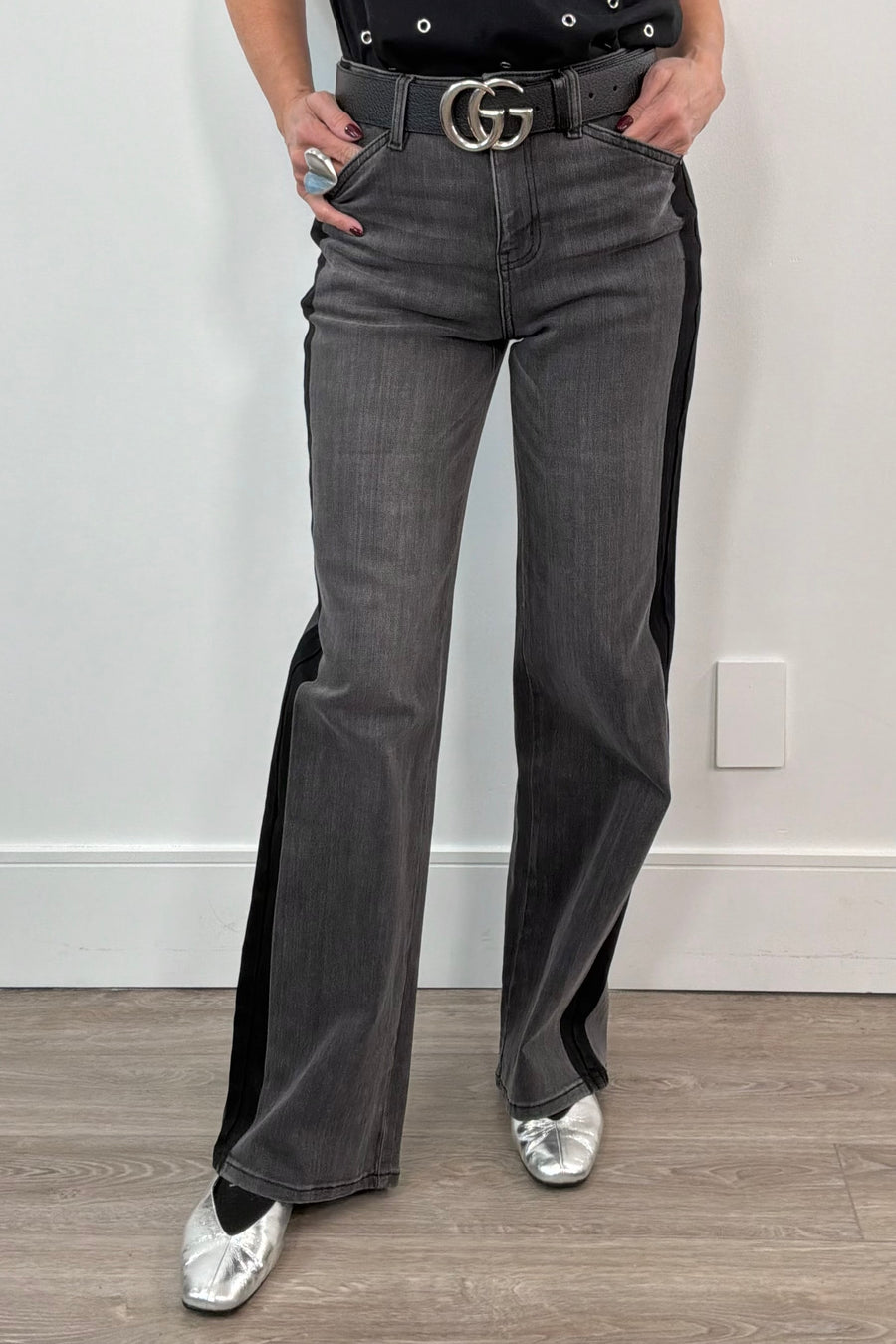 woman wearing washed black relaxed straight leg jeans with a black stripe on the sides