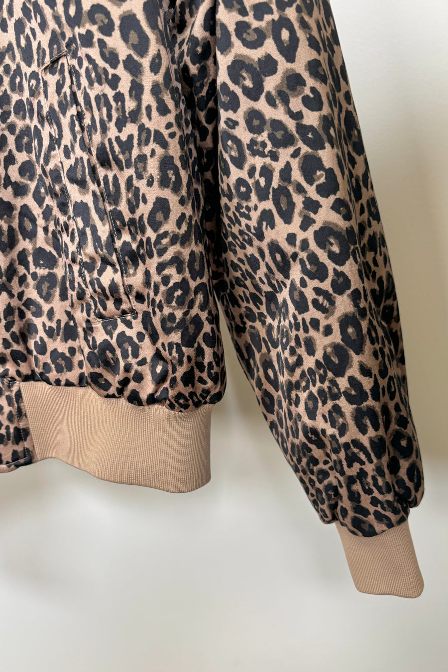 Close up of the cuff of a zipped up leopard print bomber jacket