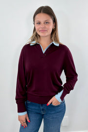 Woman wearing a burgundy sweater with a blue collar
