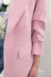 Close-up of the pocket of a pink open blazer
