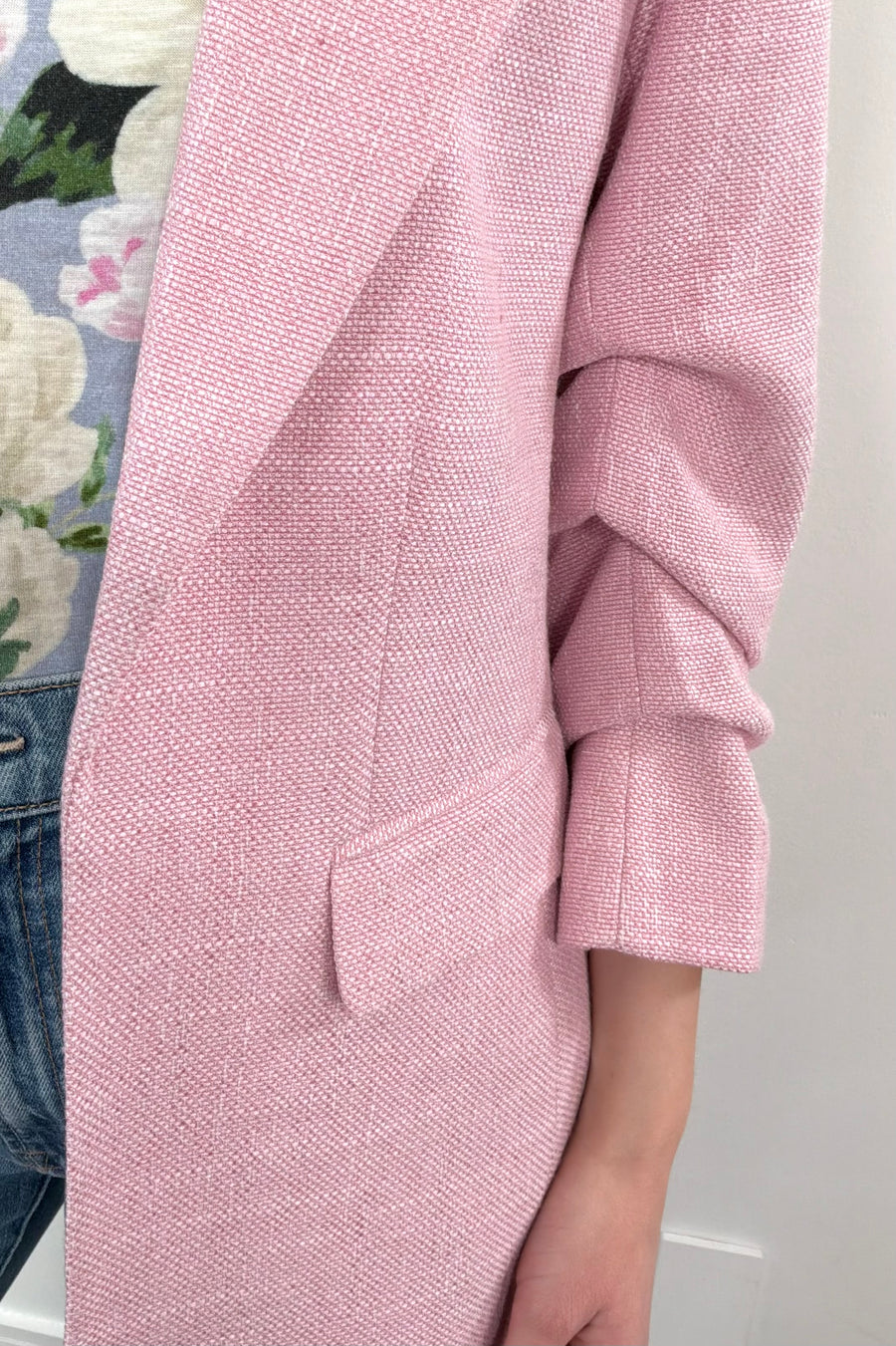 Close-up of the pocket of a pink open blazer