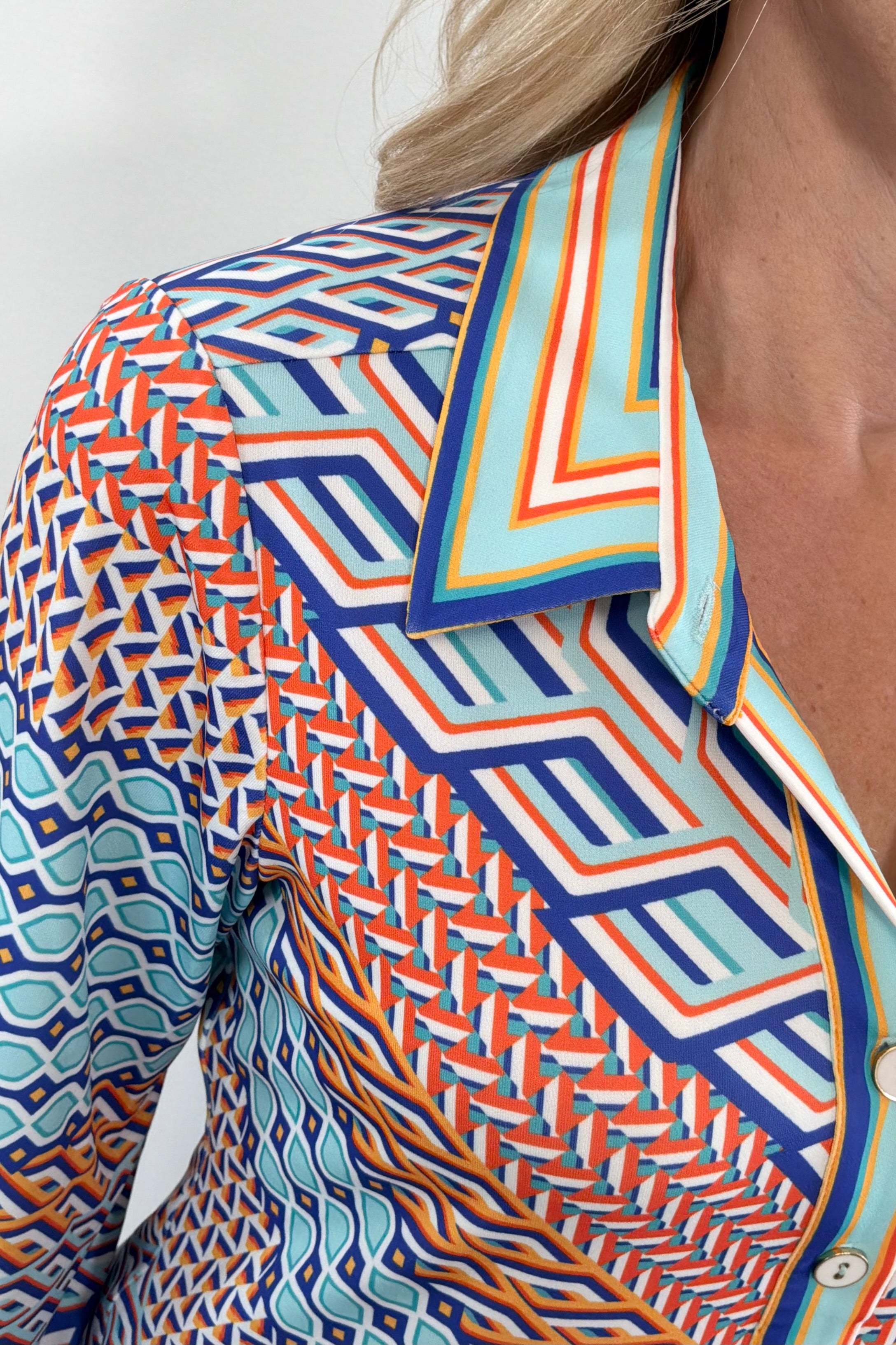 Close up of Woman wearing a blue turquoise and orange patterned dress 