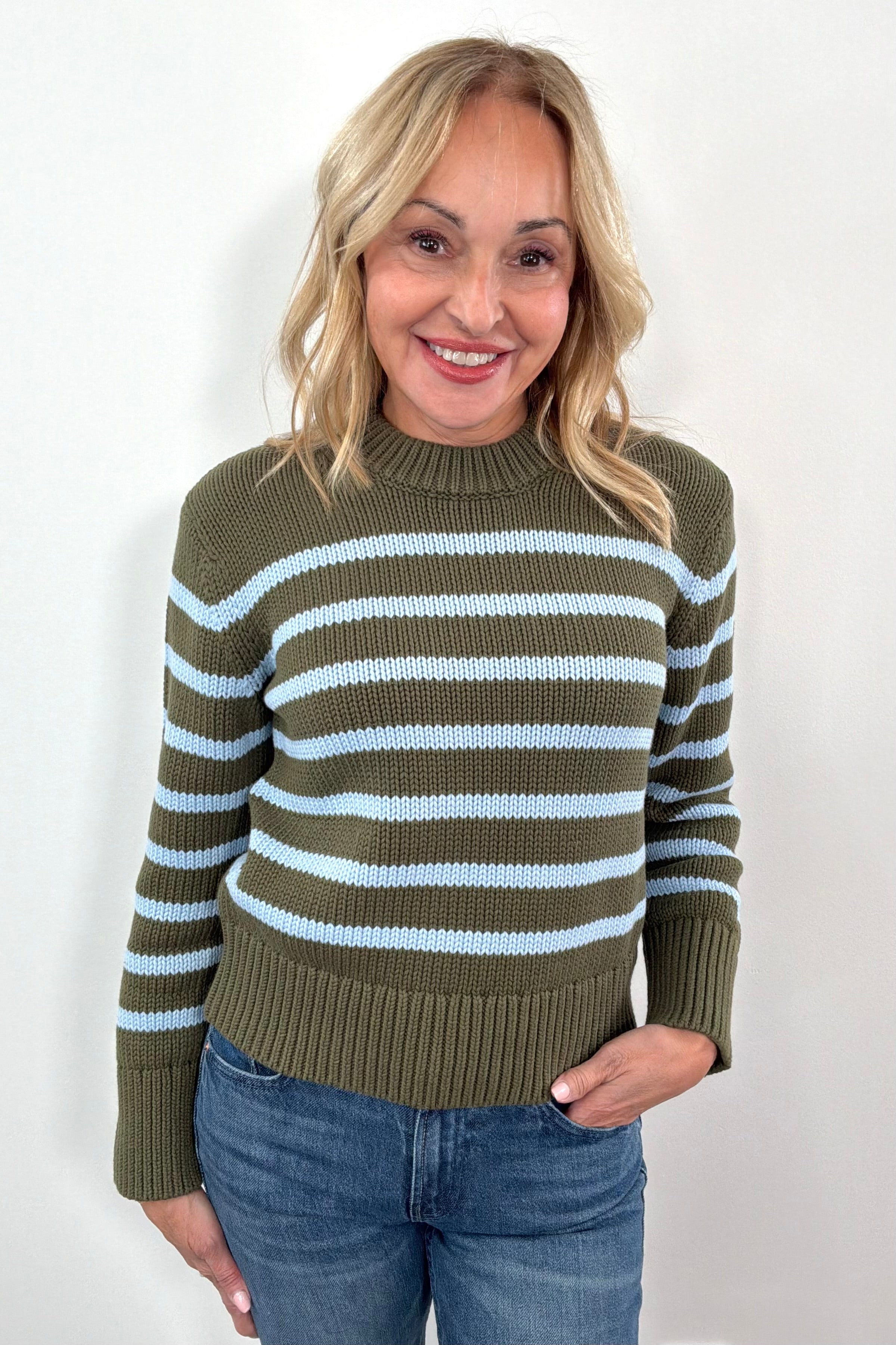 Woman wearing a green and blue striped sweater 