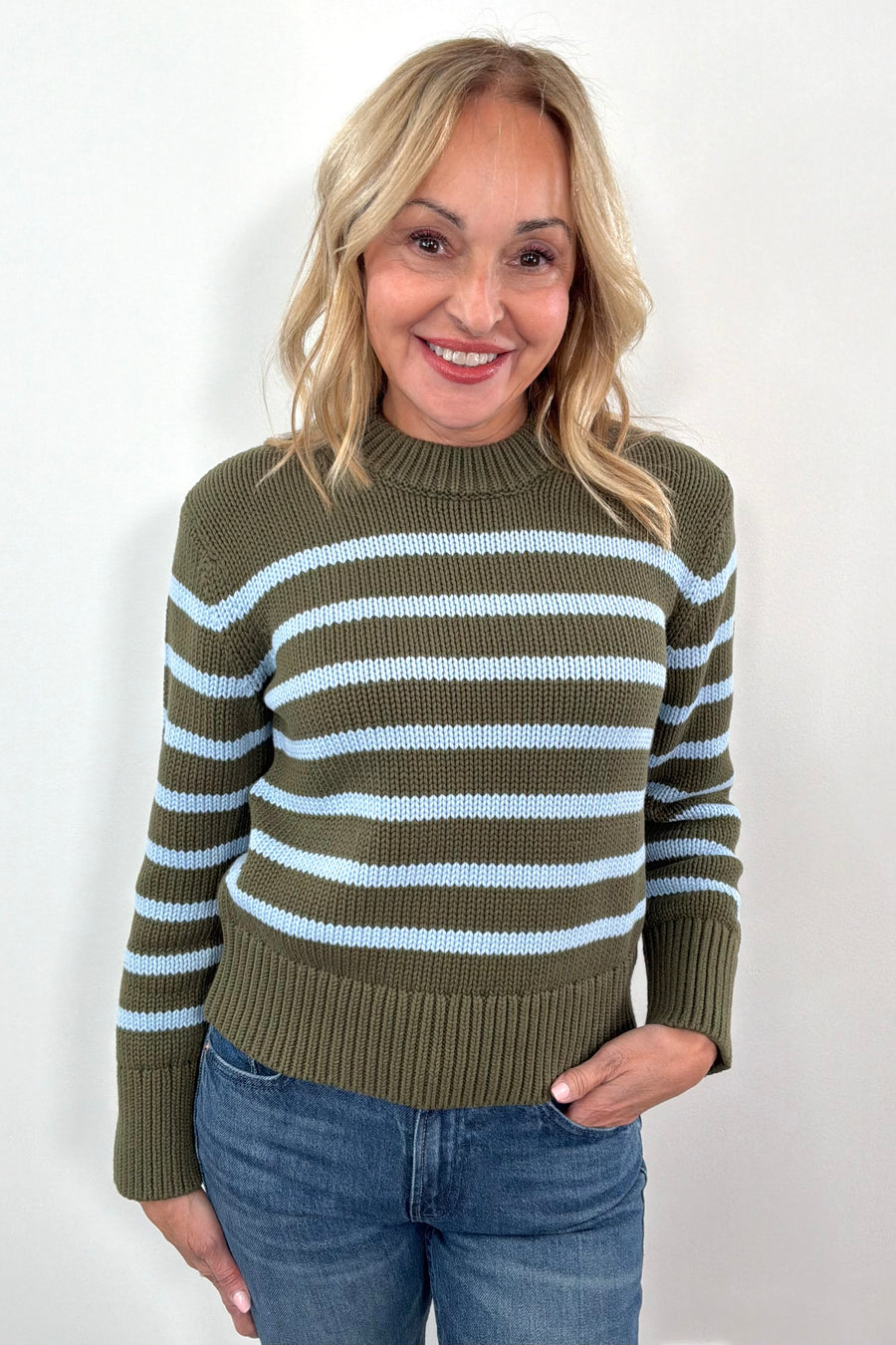 Woman wearing a green and blue striped sweater 