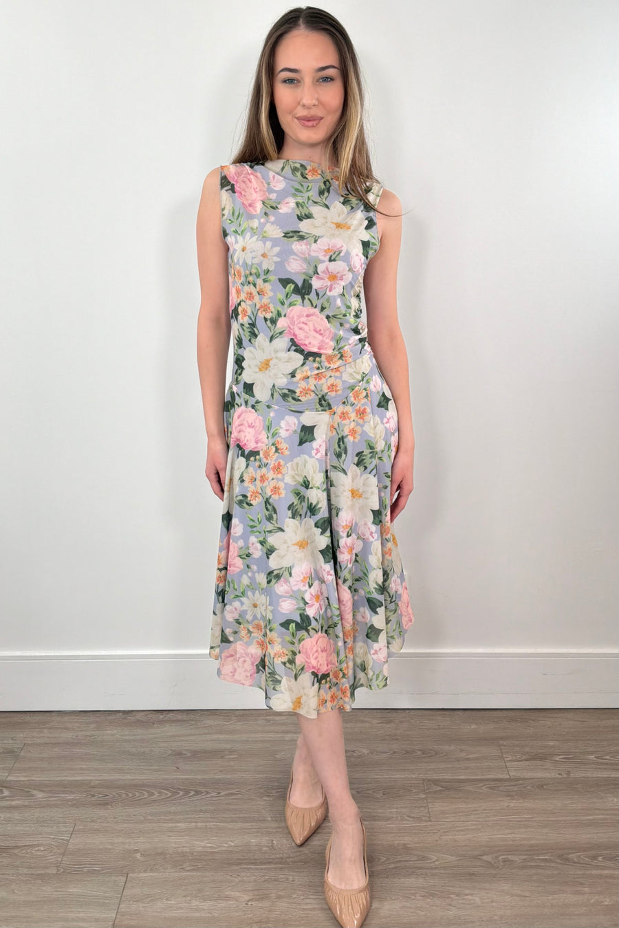 a woman wearing a floral print sleeveless midi asymmetrical dress 