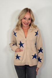 woman wearing a beige zip-up sweater with blue star patterns and front pockets