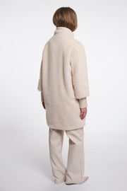 Woman wearing a beige fluffy coat. 