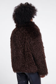 Woman wearing a brown faux fur jacket in chocolate brown. 