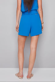 woman wearing blue vegan silk shorts with a bow belt