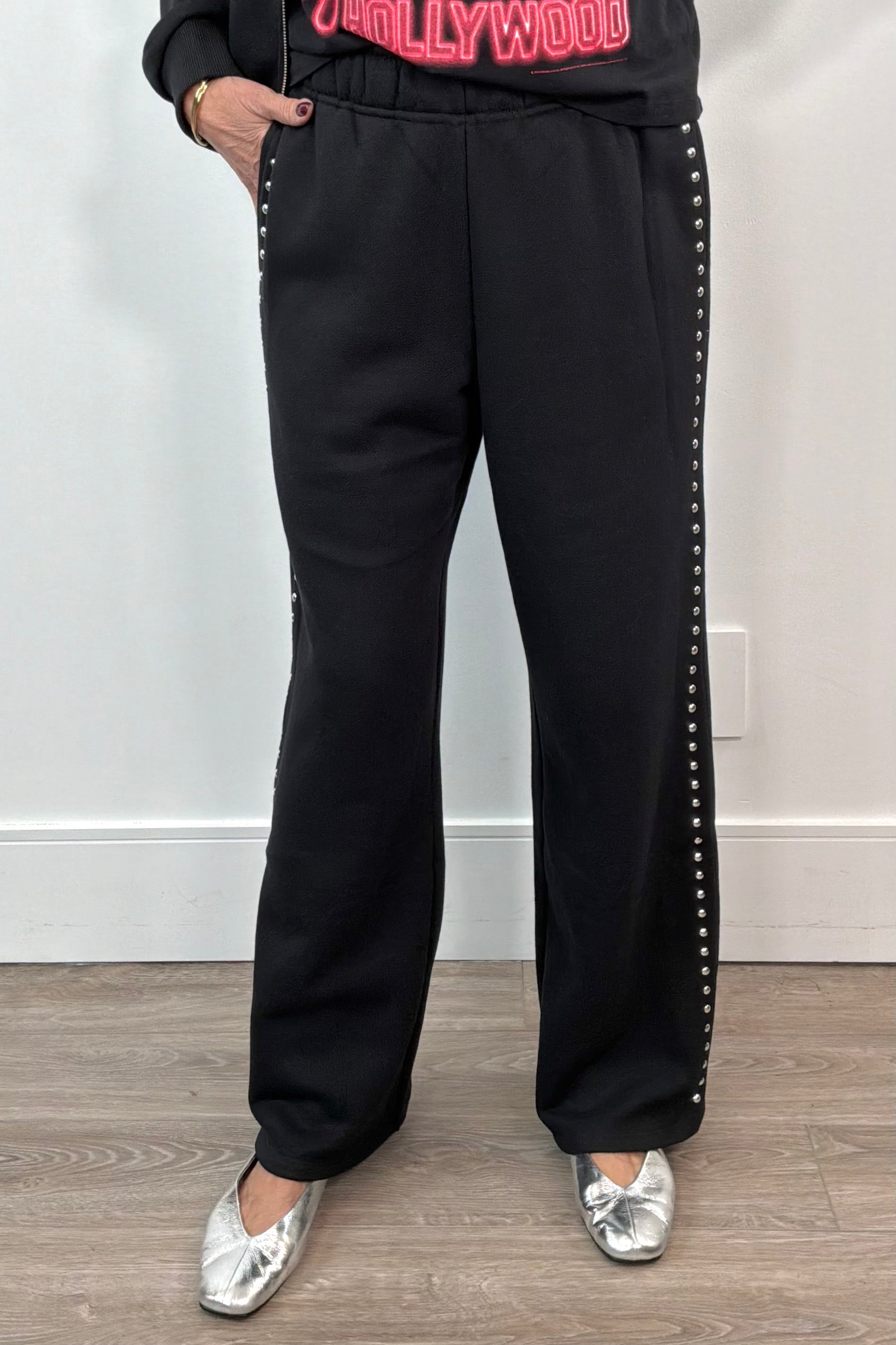 woman wearing black pants with studded side panels 