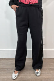 woman wearing black pants with studded side panels 