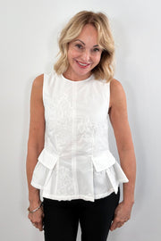 Woman wearing a white sleeveless round neck top with 3D mesh floral details 