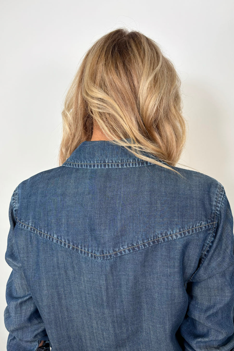 Back view of woman wearing a western snap blue shirt 