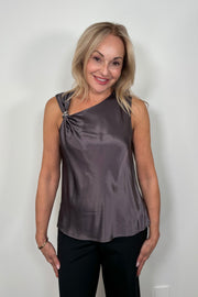 Front view of woman wearing a deep metallic gray satin tank top with a silver metal detail