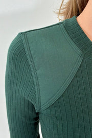 Closeup of Woman wearing a green knitted long sleeve 
