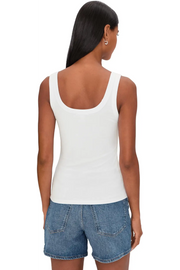 Woman wearing a white ribbed tank top with scoop neckline