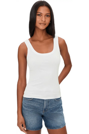 Woman wearing a white ribbed tank top with scoop neckline