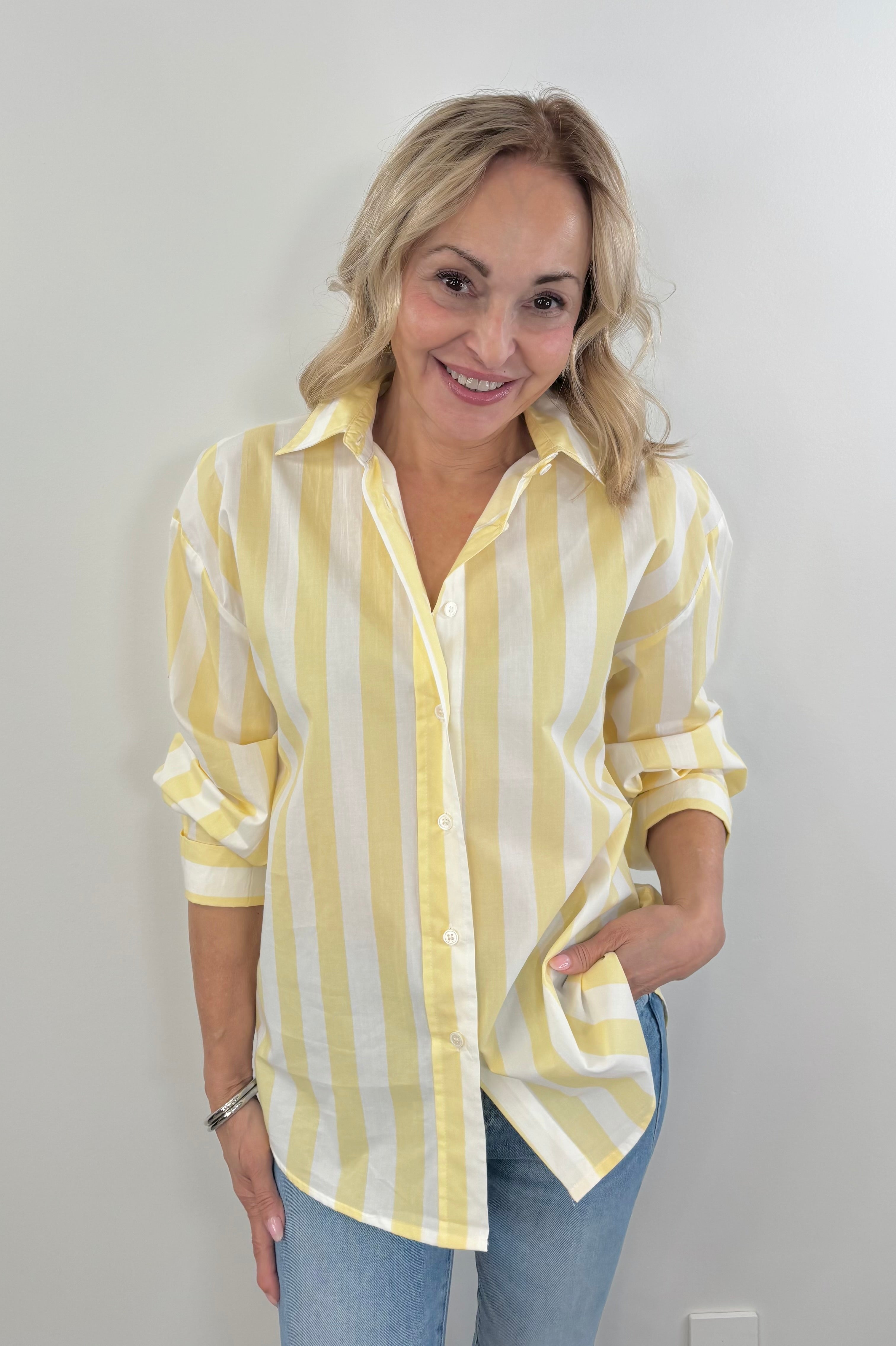 Woman wearing a striped yellow and white button up shirt