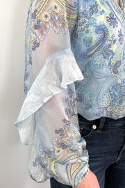 Close-up of a blue paisley patterned silk ruffle blouse