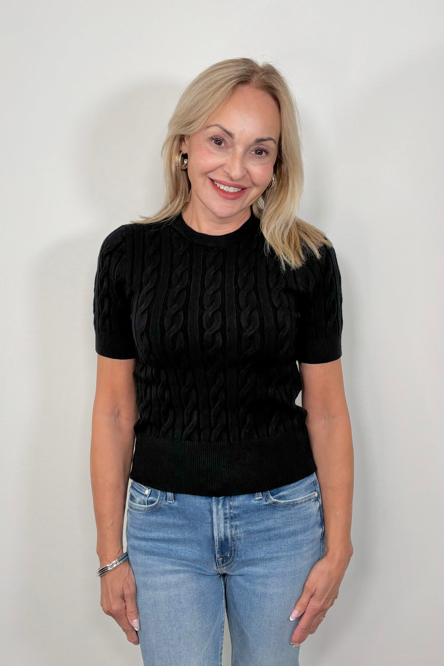 Front view of woman wearing a black coloured cable knit top