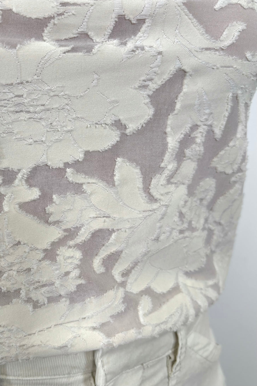 close up of an off white lace-like long sleeve