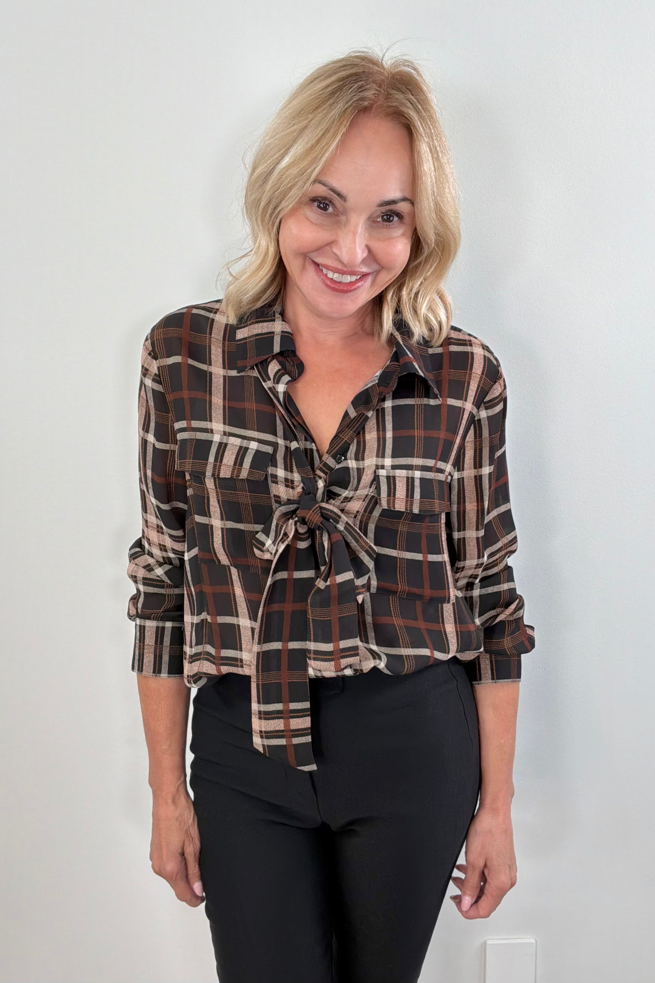 Woman wearing a plaid shirt with a bow