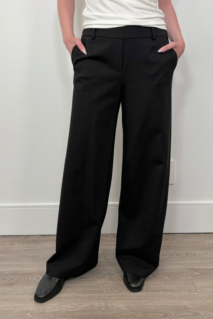 Front view of woman wearing a black wide leg ponte pant