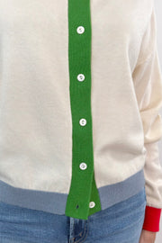 Close-up of a cream cardigan with a green, blue, red and purple accents.