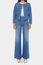 Woman wearing a mid blue wash denim jacket with custom mother buttons