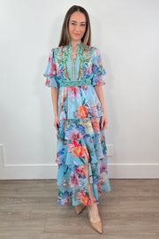 woman wearing a teal floral ruffle maxi dress 