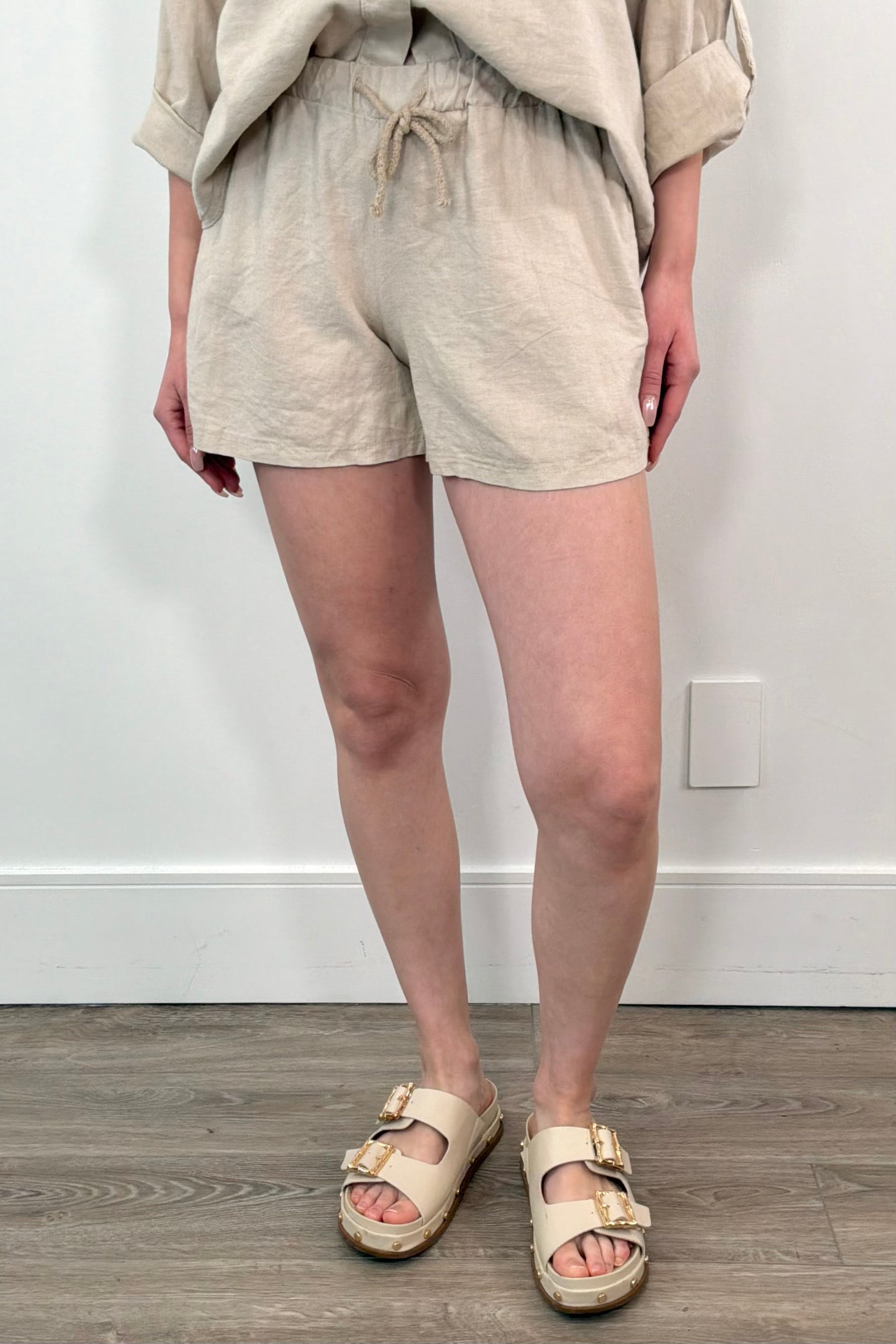 Woman wearing cotton beach shorts in sand with drawstring waistband