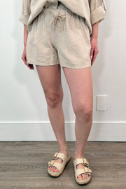 Woman wearing cotton beach shorts in sand with drawstring waistband
