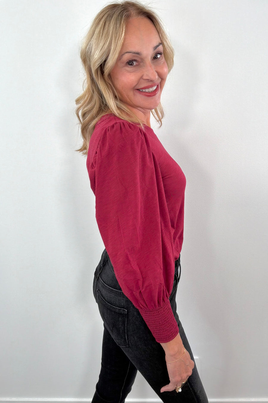 Woman wearing a red blouse with puffed sleeves 