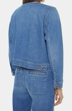 Back view of woman wearing a mid washed blue denim jacket with custom mother buttons