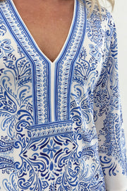 Close up of Woman wearing white dress with blue pattern allover