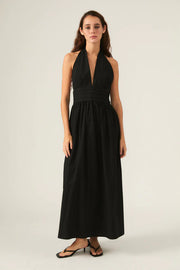 Woman wearing a black halter neck dress. 