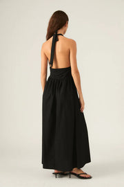 Woman wearing a black halter neck dress. 