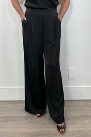 Front view of woman wearing a satin black wide leg pant