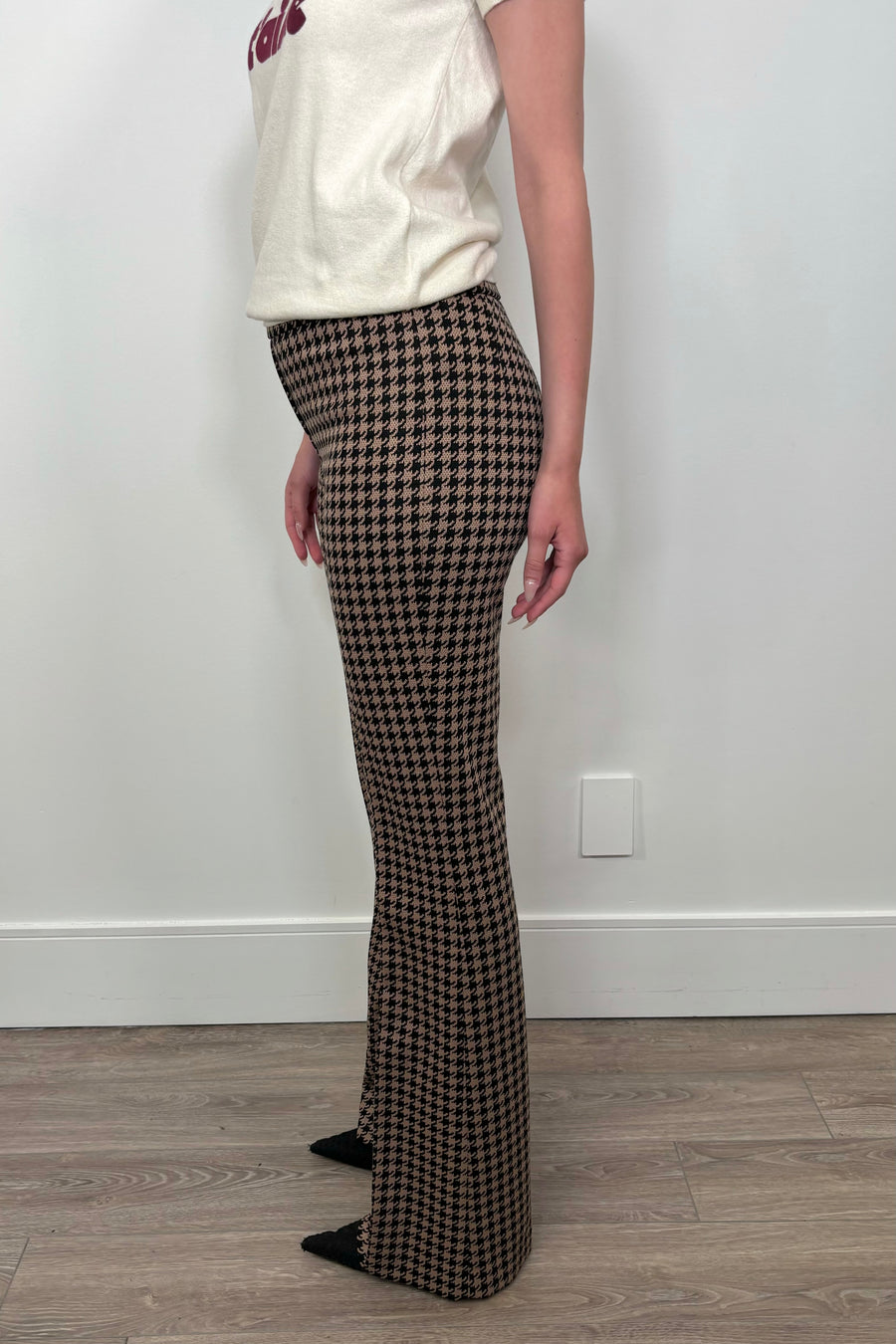 Side view of woman wearing a houndstooth print knit pant