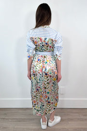 woman wearing a white and blue striped dress with a silk floral patterns belted