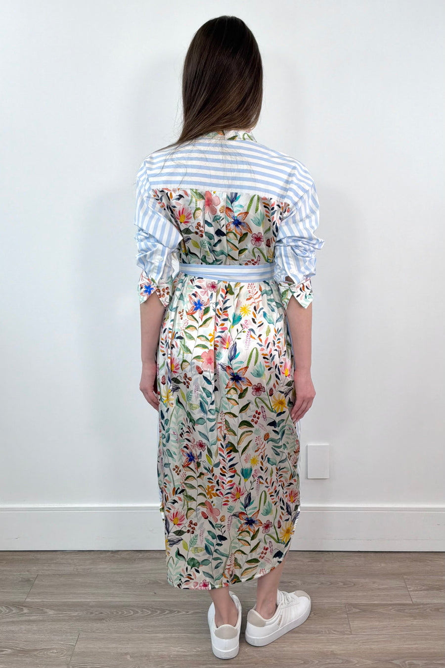 woman wearing a white and blue striped dress with a silk floral patterns belted