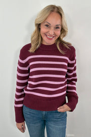 Woman wearing a maroon and pink striped sweater 