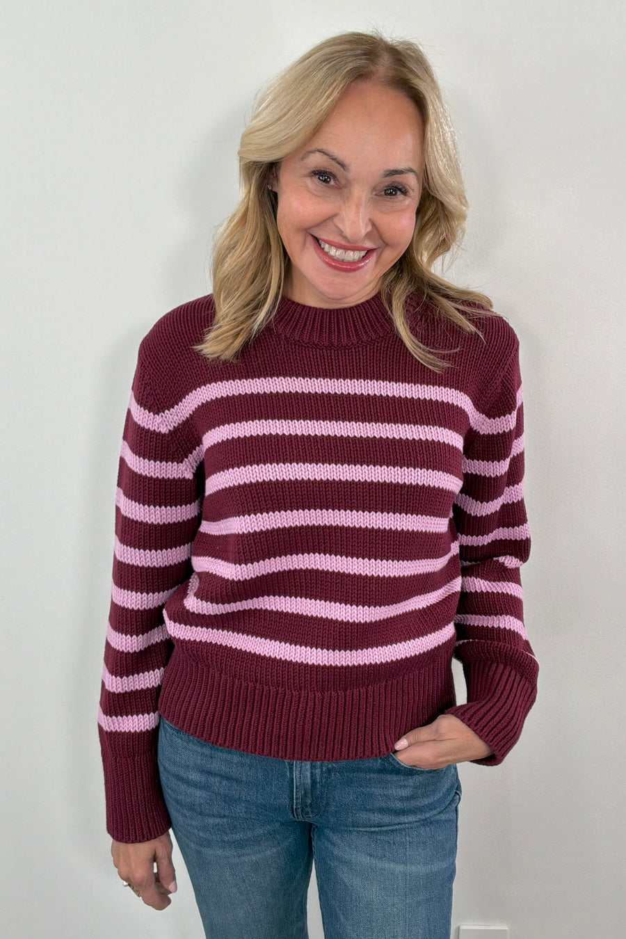 Woman wearing a maroon and pink striped sweater 