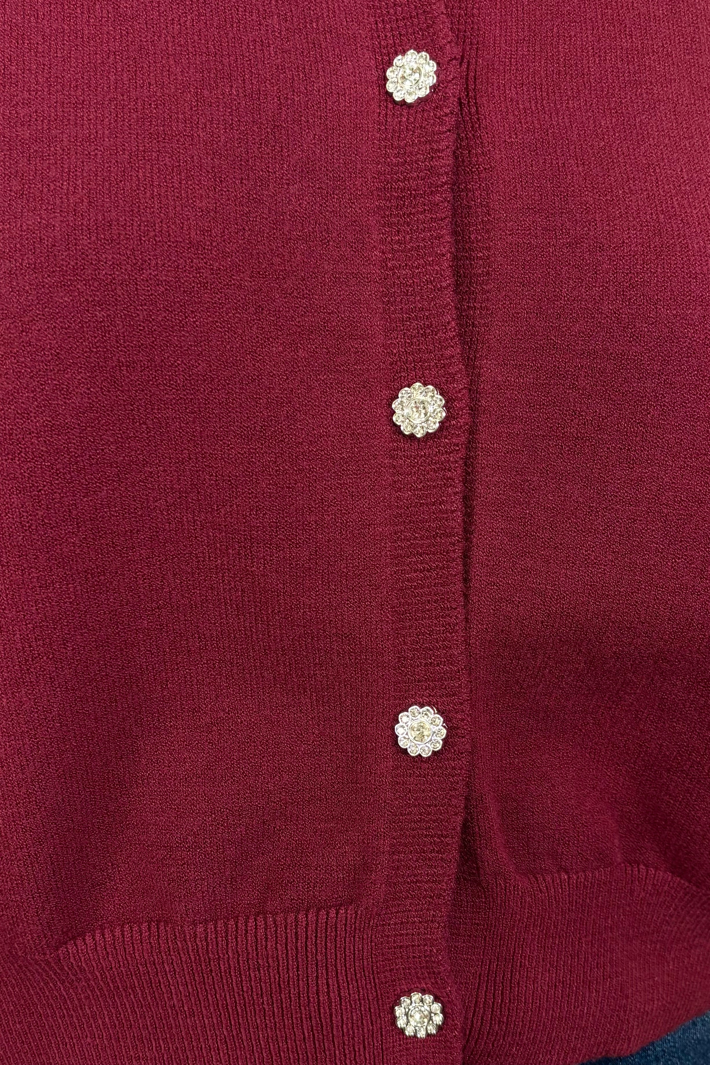 Close-up of a burgundy crystal button cardigan