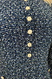 Close-up view of woman wearing a blue tweed short dress