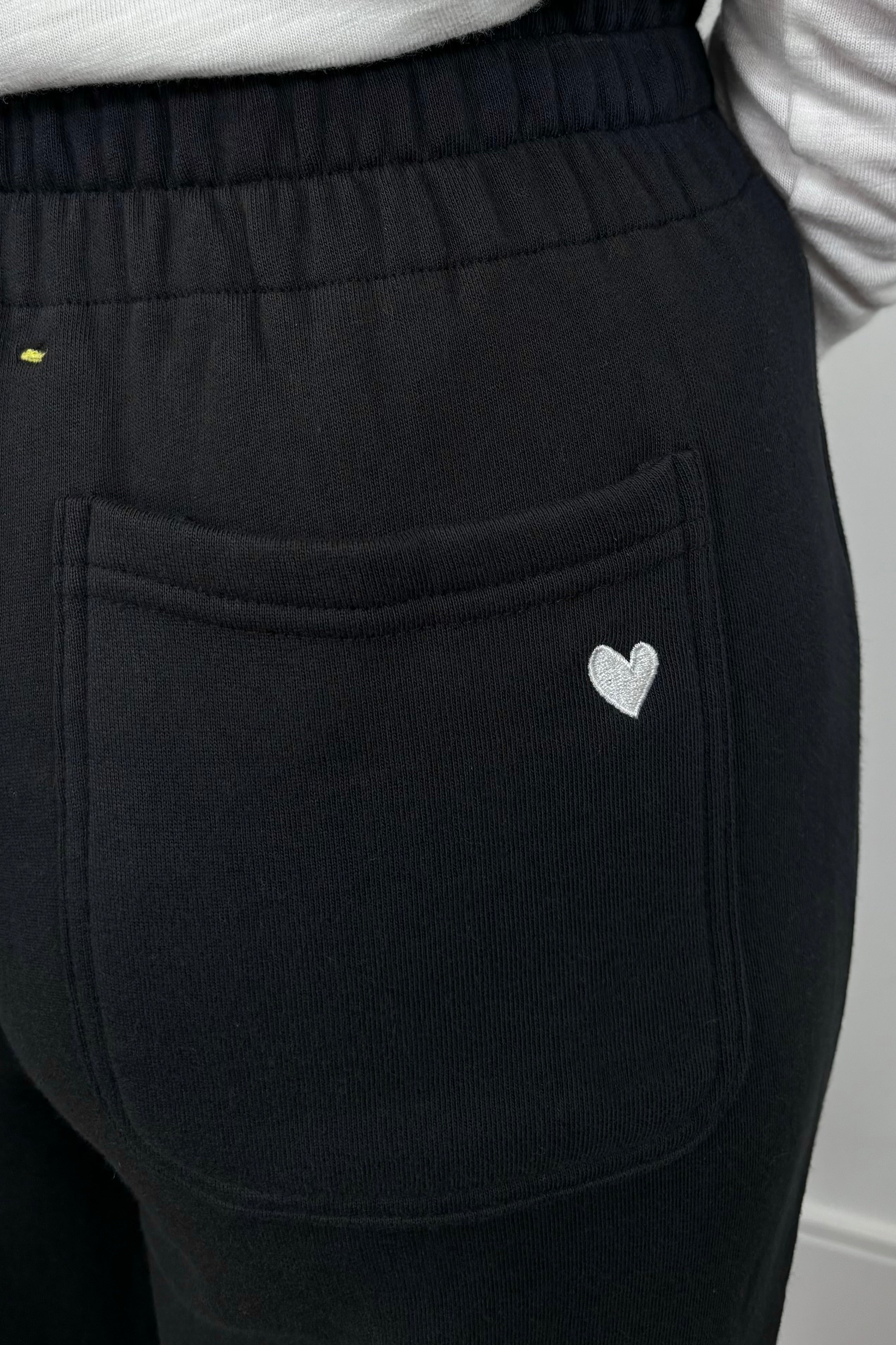 Close up of the back pocket of a wide leg black sweatpant
